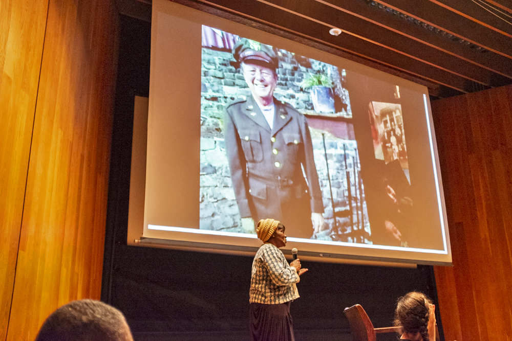 Participant shares a projected photo of a person in uniform onstage