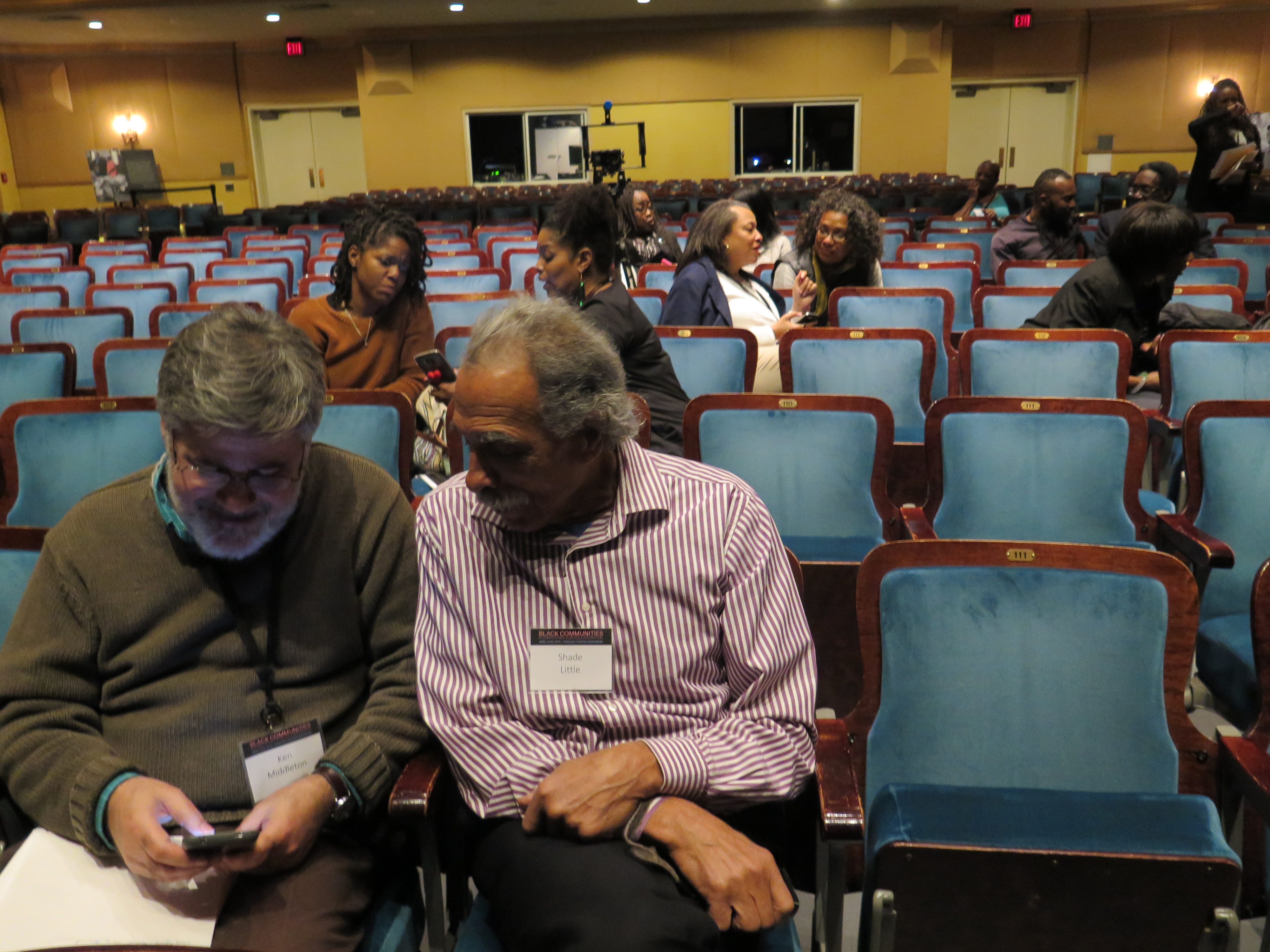 Two participants examine a photo at the Black Communities Conference
